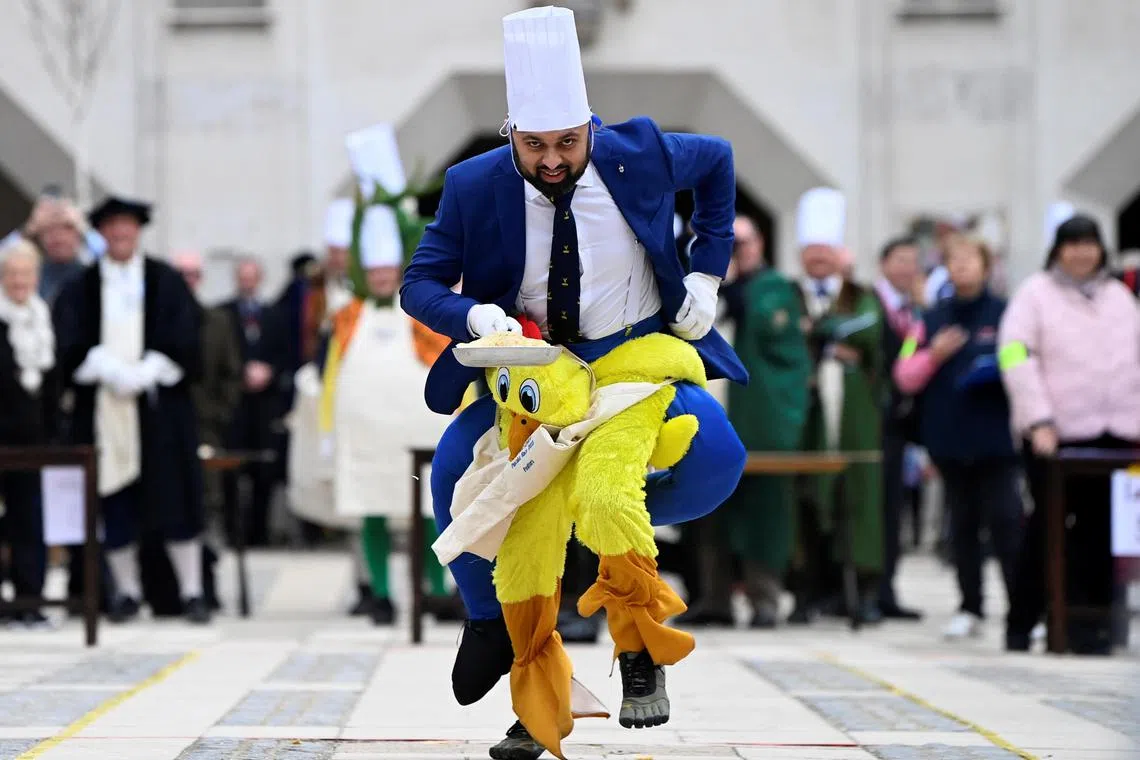 Worker from one of the City Company professions wears a costume as he takes part in the Shrove Tuesday Inter-Livery Pancake Race at the Guildhall in the City of London, in London, Britain, February 21, 2023. REUTERS/Toby Melville