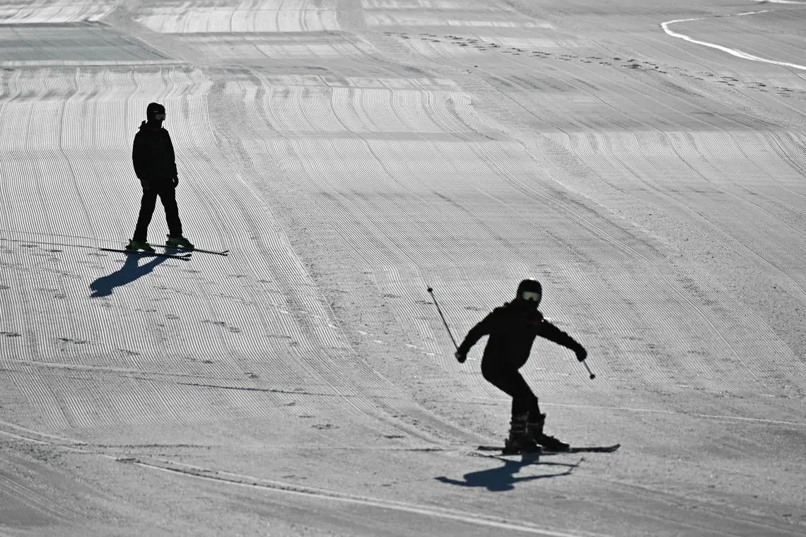 Visitors skiing on the downhill slopes at Lianhuashan Ski Resort on the outskirts of Beijing on Feb 16.
