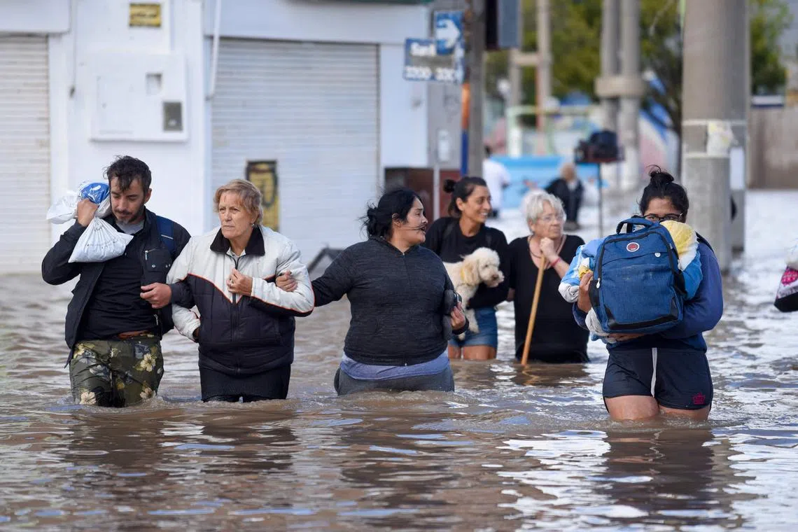 People walking through flooded waters on March 8, the day after a heavy storm struck the Argentine city of Bahia Blanca.  