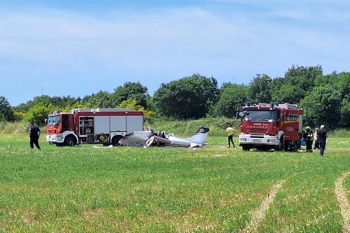 Rescue workers standing next to a small plane that crashed in the northwestern Croatian region of Istria, near the Adriatic town of Medulin, on June 4.
