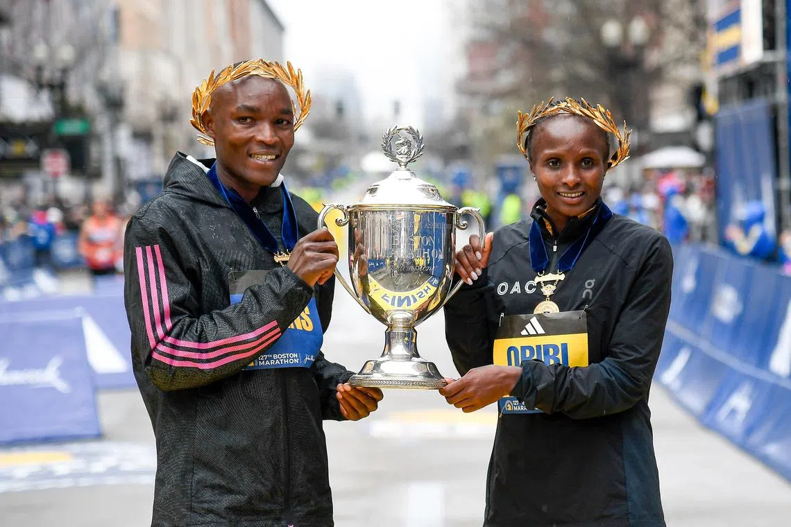 Evans Chebet of Kenya (left) and Hellen Obiri of Kenya pose with the winner's trophy.
