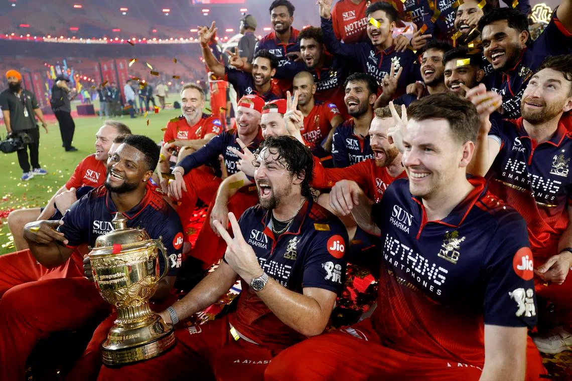 Cricket - Indian Premier League - IPL - Final - Royal Challengers Bengaluru v Gujarat Titans - Narendra Modi Stadium, Ahmedabad, India - May 31, 2026 Royal Challengers Bengaluru's Tim David lifts the trophy as he celebrates with teammates after winning the Indian Premier League REUTERS/Amit Dave