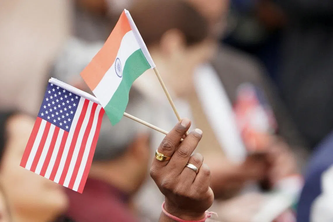 FILE PHOTO: An attendee holds U.S. and India's flags as they gather on the South Lawn of the White House to watch an official State Arrival ceremony as U.S. President Joe Biden hosts India's Prime Minister Narendra Modi for a State Visit at the White House in Washington, U.S., June 22, 2023. REUTERS/Kevin Lamarque/File Photo