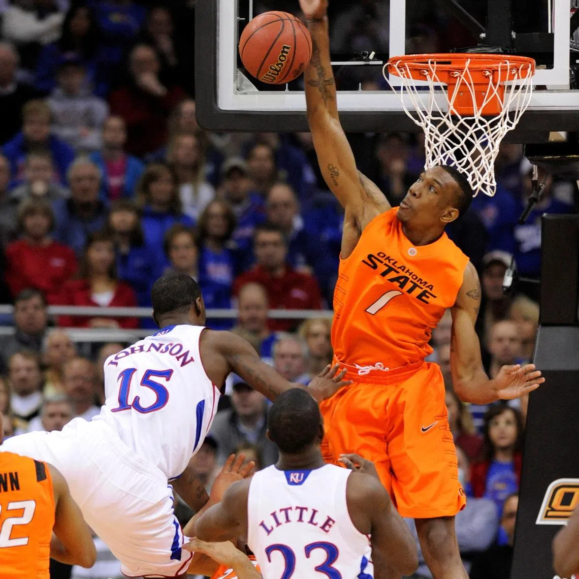 FILE PHOTO: Oklahoma State Cowboys forward Jarred Shaw rejects a shot by Kansas Jayhawk guard Elijah Johnson (L) during the first half of the quarter-finals of the NCAA men's Big 12 basketball championship at the Sprint Center in Kansas City, Missouri, March 10, 2011. REUTER/Dave Kaup/File Photo