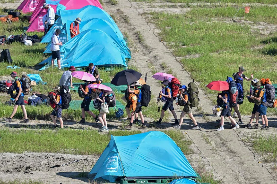 TOPSHOT - Scouts prepare to leave the campsite of the World Scout Jamboree in Buan, North Jeolla province on August 8, 2023. Organisers of the World Scout Jamboree asked host South Korea on August 7 to "urgently" evacuate tens of thousands of children from their campsite ahead of a typhoon, just days after a heatwave caused mass scout illnesses. (Photo by Anthony WALLACE / AFP)