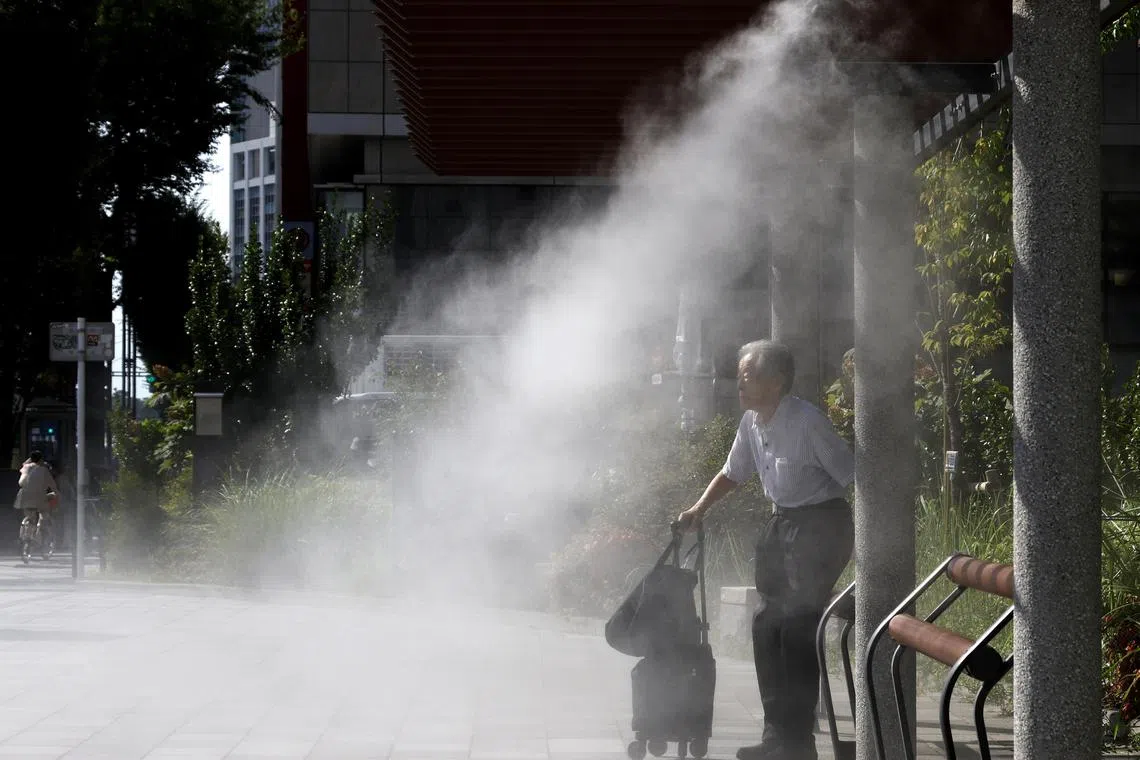 An elderly man sitting under a cooling mist station during a heatwave in Tokyo on July 24.