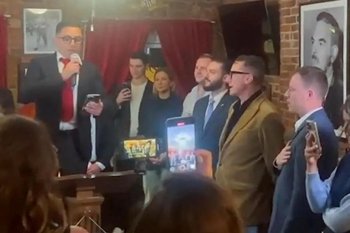 AfD lawmaker Jan Wenzel Schmidt (right) and fellow party members sing Germany, Germany Above All together with president of the New York Young Republican Club Stefano Forte (third from right), at a gathering in a Manhattan club.