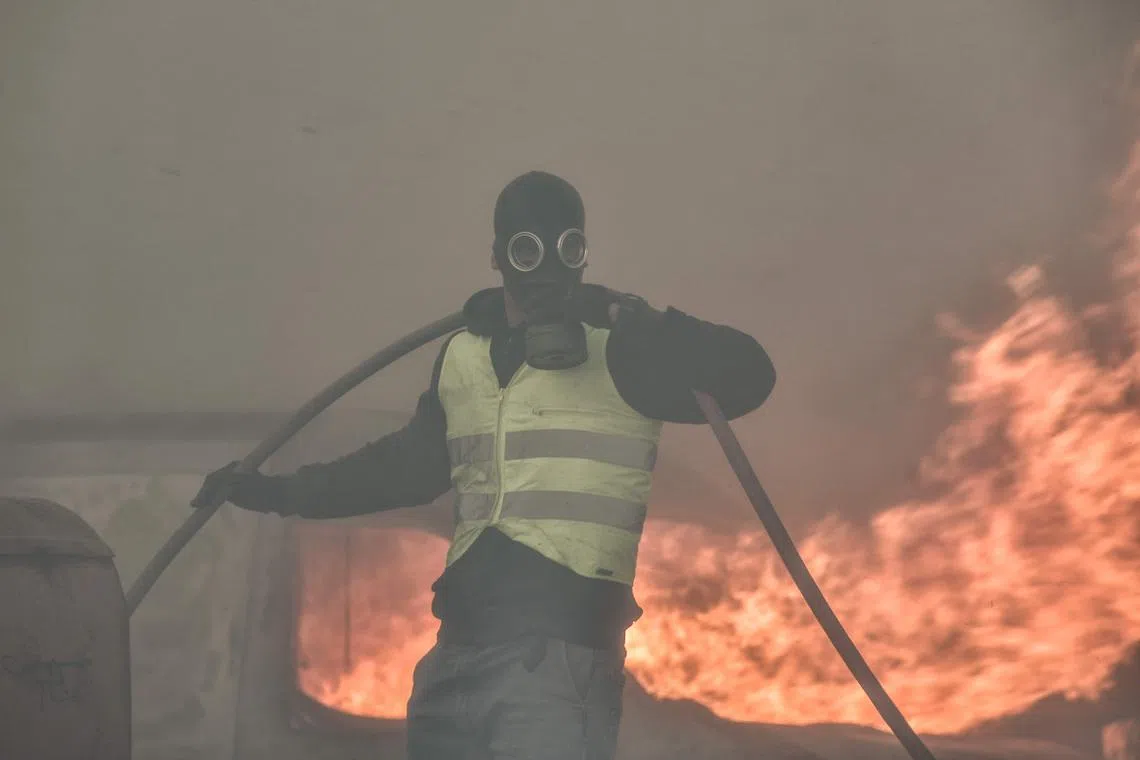 A local resident battling the raging fire in the Lagonisi area, near Athens.