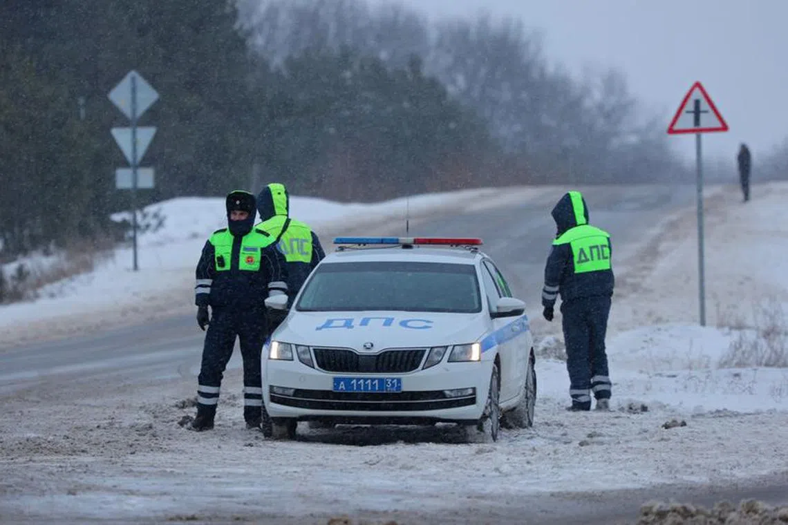 Traffic police officers stand guard on a road near the crash site of the Russian Ilyushin Il-76 military transport plane outside the village of Yablonovo in the Belgorod Region, Russia January 24, 2024. REUTERS/Stringer