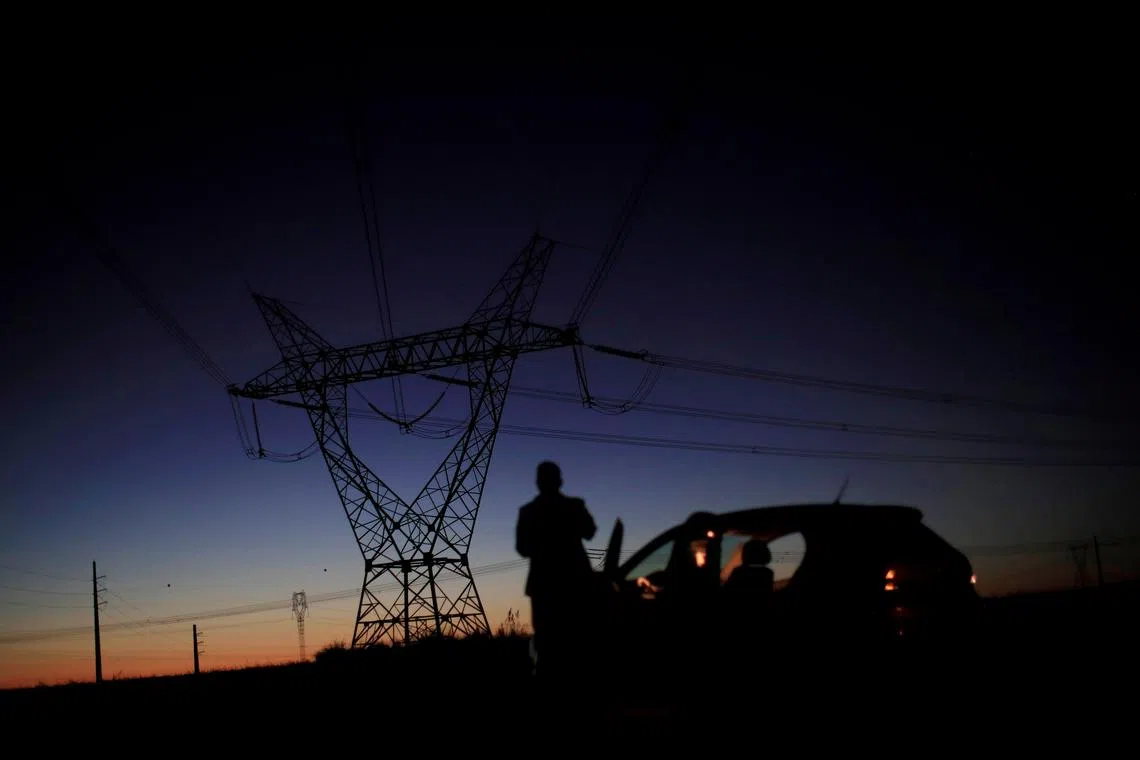 A man stands in front of power lines connecting pylons of high-tension electricity near Brasilia, Brazil August 29, 2018. Picture taken August 29, 2018. REUTERS/Ueslei Marcelino/File Photo