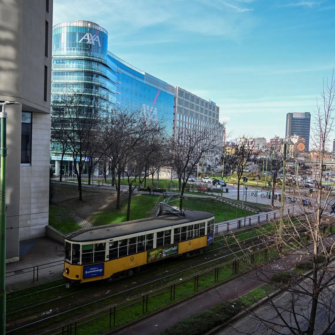 A historic tram travels along a street lined with modern office buildings in Milan, Italy, January 5, 2026. REUTERS/Daniele Mascolo