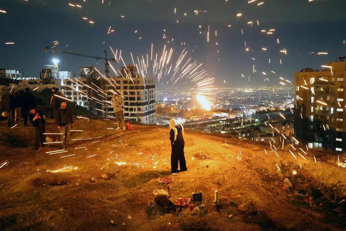 Iranians lighting fireworks during the Wednesday Fire feast, or Chaharshanbeh Soori, held annually on the last Wednesday eve before the Spring holiday of Nowruz, in Tehran, on March 18, 2025.