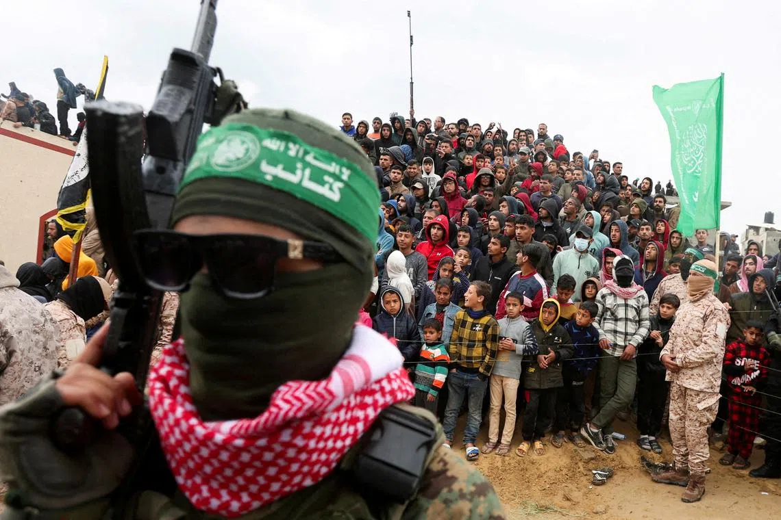 FILE PHOTO: Palestinians look on during the handover by Hamas of deceased hostages, identified at the time by Palestinian militant groups as Oded Lifschitz, Shiri Bibas and her two children Kfir and Ariel Bibas, seized during the deadly October 7, 2023 attack, to the Red Cross, as part of a ceasefire and hostages-prisoners swap deal between Hamas and Israel, in Khan Younis in the southern Gaza Strip, February 20, 2025. REUTERS/Ramadan Abed/File Photo