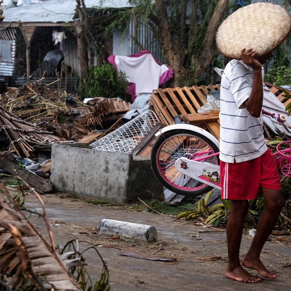 A man walks with his belongings after Cyclone Gezani tore through the port city of Toamasina, on the island of Madagascar, leaving a trail of destruction, February 12, 2026. REUTERS/Stringer