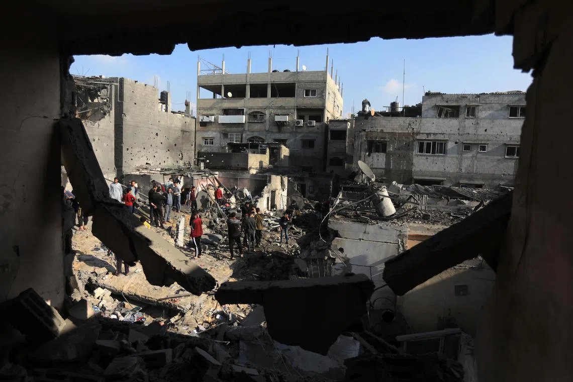 Palestinians survey the damage after an Israeli airstrike on Khan Younis, in southern Gaza, on Dec 1, 2023.