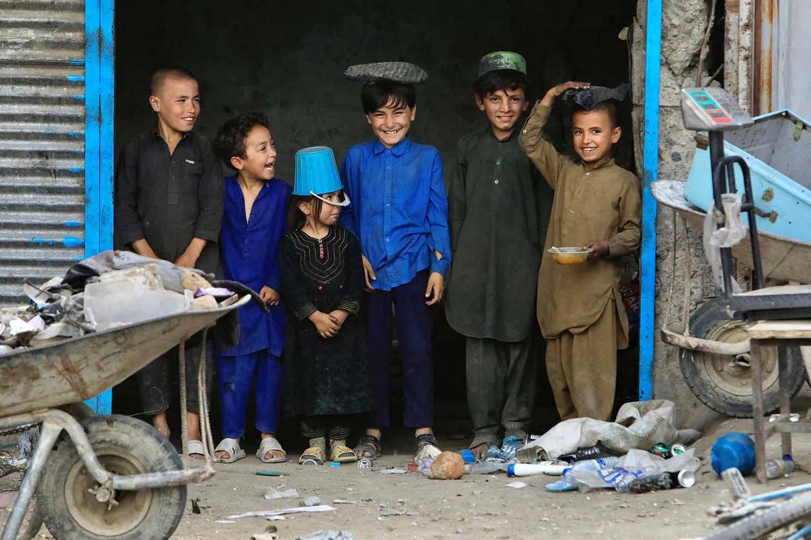 Afghan children standing at a scrap shop outside a World Food Program distribution centre in Kabul, Afghanistan, Aug 21, 2024. 