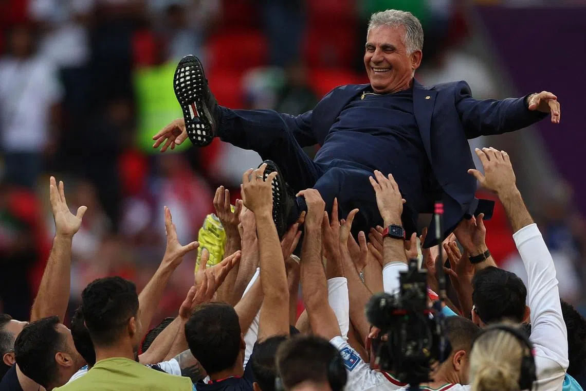 Iran's players celebrate their World Cup Group B victory over Wales with Portuguese coach Carlos Queiroz at the Ahmad Bin Ali Stadium in Al-Rayyan, west of Doha on Friday.