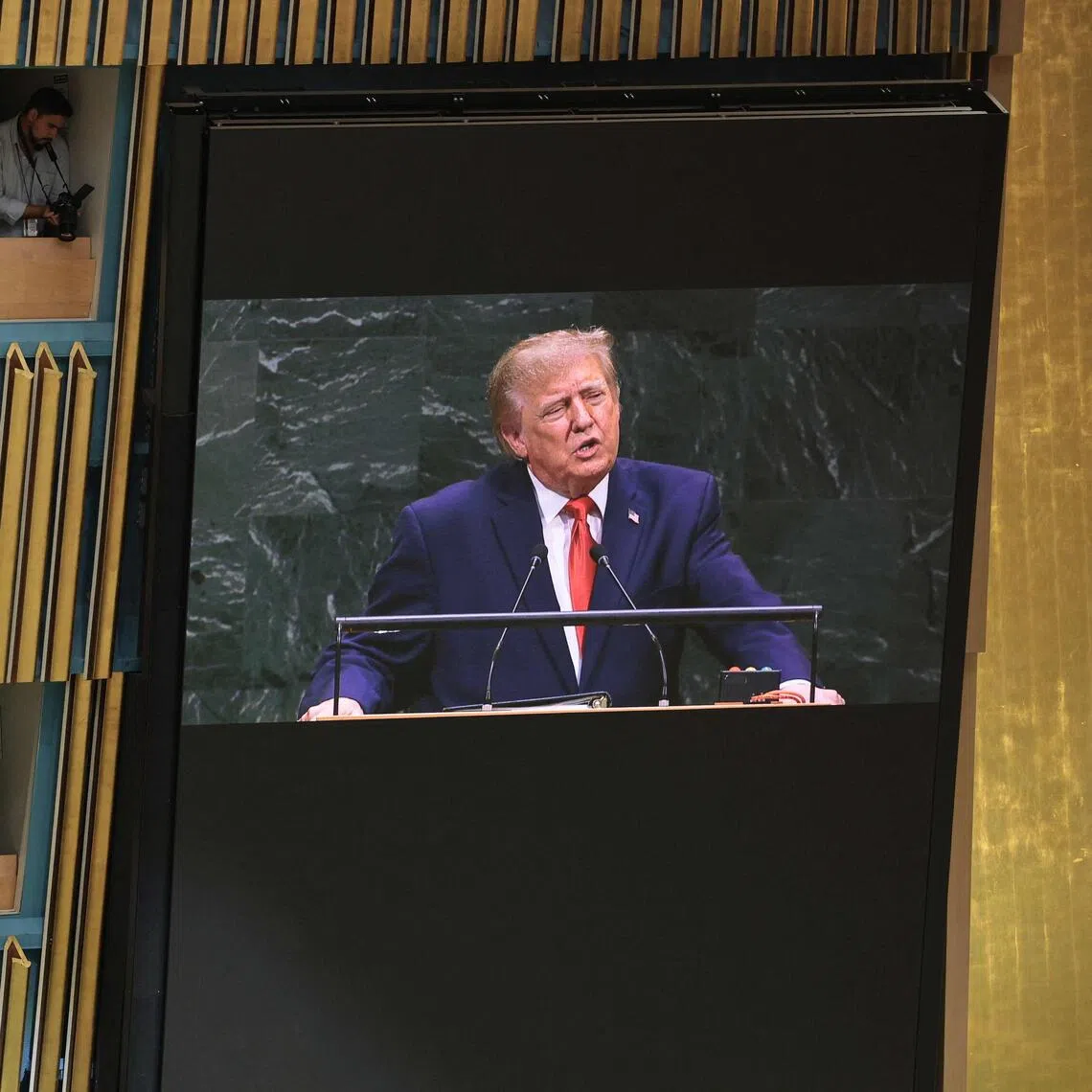 US President Donald Trump is seen on a screen delivering an address to the United Nations General Assembly on Sept 22, in New York City.