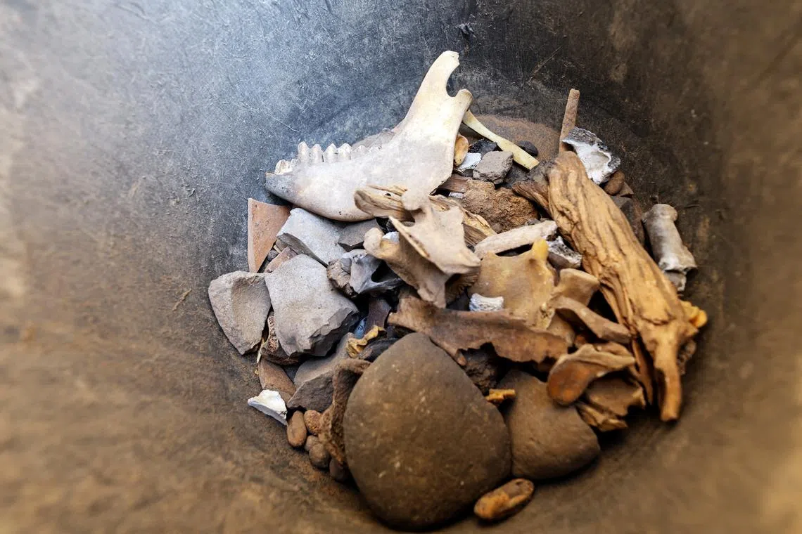 Findings are seen in a bucket by the entrance to a desert cliff excavation overseen by the Israel Antiquities Authority in Muraba'at Cave near the Dead Sea, in the Israeli-occupied West Bank December 28, 2022. 