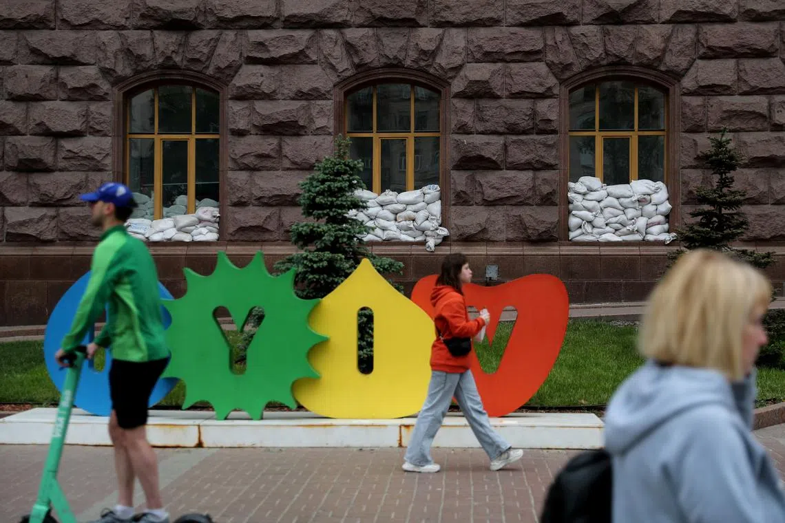 FILE PHOTO: Sandbags are placed on a public building's windows while local residents walk past a sign reading 'Kyiv', as Russia's attack on Ukraine continues, in Kyiv, Ukraine May 22, 2022. REUTERS/Ivan Alvarado/File Photo