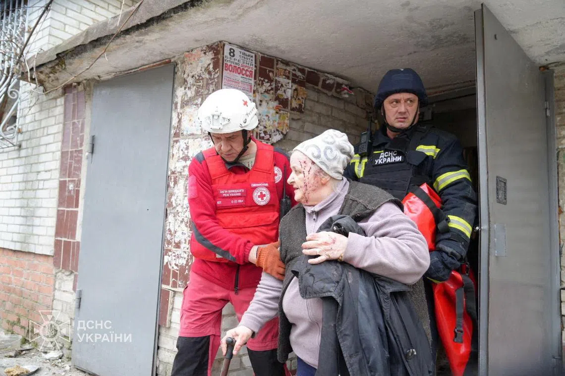 A medical worker evacuating a wounded woman from an apartment building damaged during a Russian missile strike, in Sumy, Ukraine, on March 24.