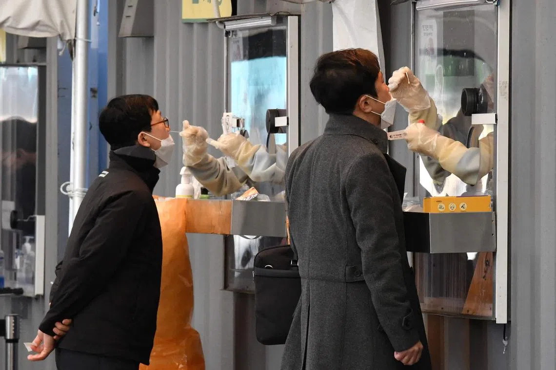 A medical staff takes a nasal swab from a visitor as part of a test for the Covid-19 coronavirus at a testing centre in Seoul, in the file photo.