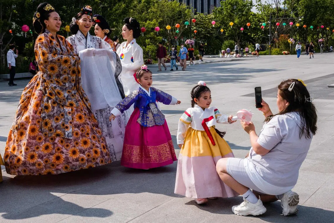 People wear traditional Hanbok clothing as they attend a culture festival in Seoul in Seoul on May 19, 2023. (Photo by ANTHONY WALLACE / AFP)