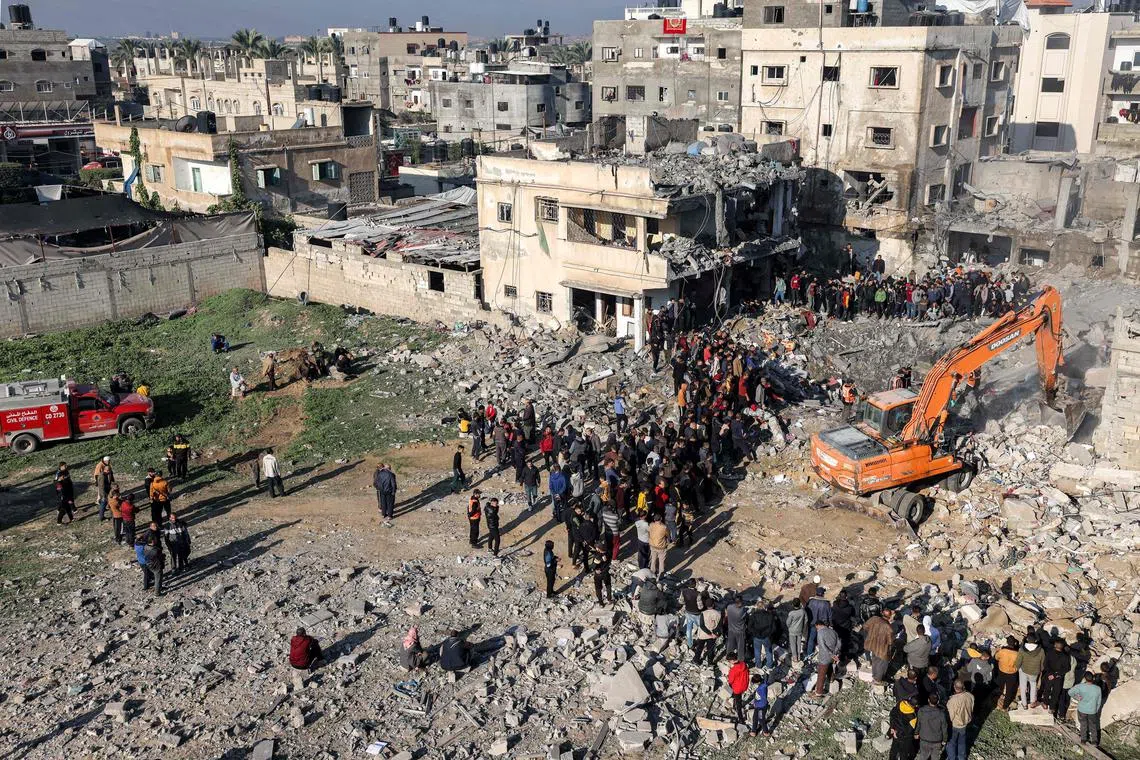 Excavators dig through the rubble of a building destroyed by Israeli bombardment in Rafah in the southern Gaza Strip, on Dec 19.
