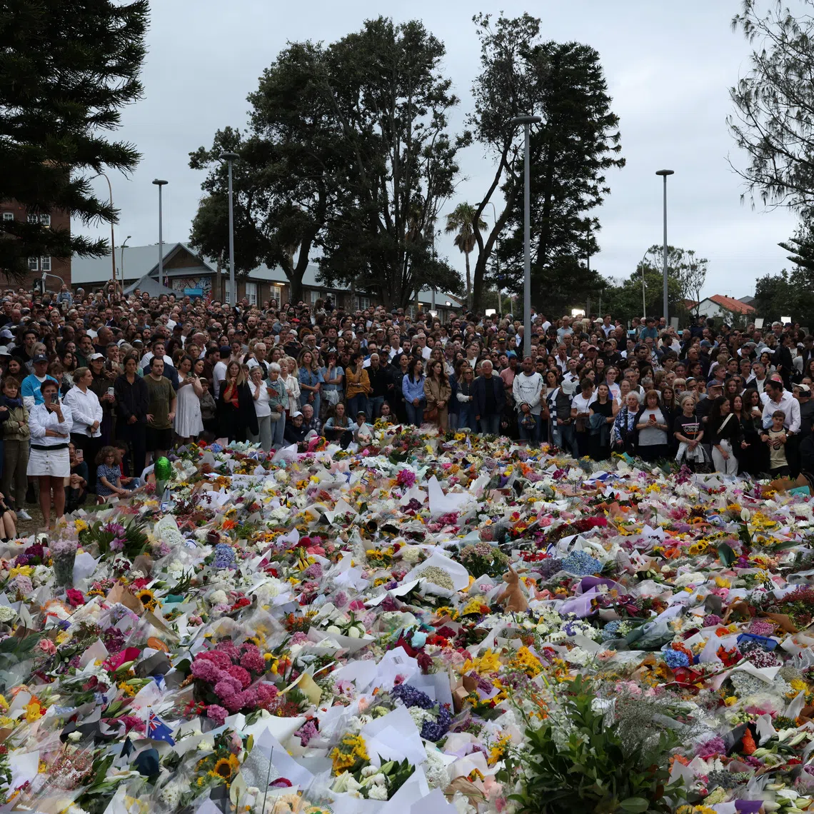 People lay flowers and pay tributes at Bondi Beach to honour the victims of a mass shooting that targeted a Jewish Holiday celebration on Sunday at Bondi Beach, in Sydney, Australia, December 16, 2025. REUTERS/Hollie Adams