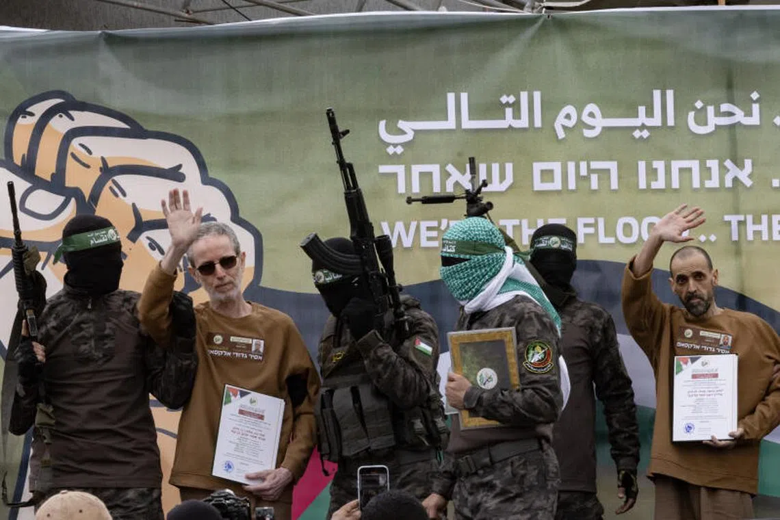 Caption:
Hamas fighters escort the hostages Ohad Ben Ami, left and Eli Sharabi to be exchanged in Deir al-Balah, in the Gaza Strip on Saturday, Feb. 8, 2025. In remarks effectively delivered at gunpoint, one of the three hostages exchanged on Saturday thanked Hamas fighters for ÒprotectingÓ him and called for the Israeli government to end the war. (Saher Alghorra/The New York Times)