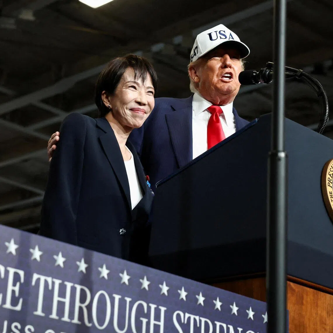 FILE PHOTO: Japanese Prime Minister Sanae Takaichi reacts as U.S. President Donald Trump speaks, aboard the aircraft carrier USS George Washington, during a visit to U.S. Navy's Yokosuka base in Yokosuka, Japan, October 28, 2025. REUTERS/Evelyn Hockstein/File Photo