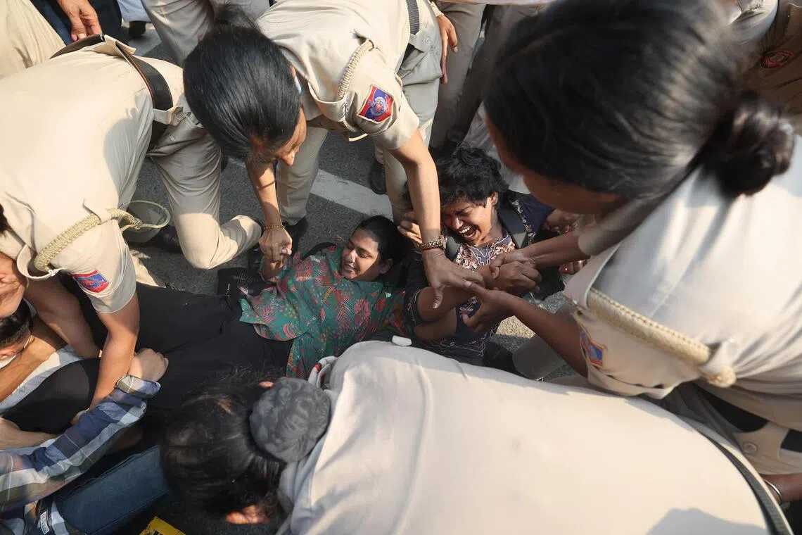 Indian police detain student activists as they take part in a protest.