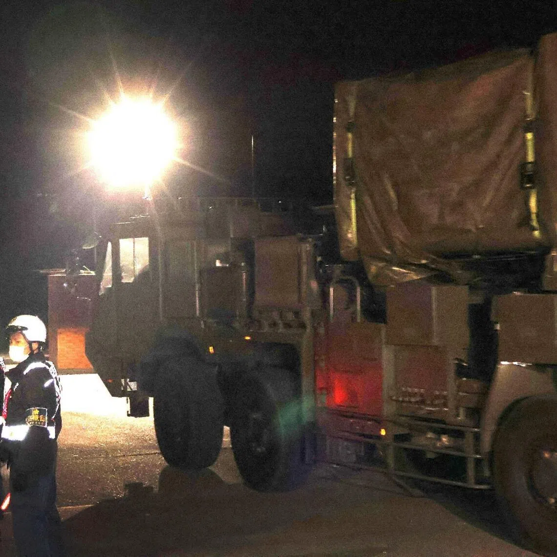 A truck believed to be carrying long-range missile-related equipment enters a military base in Kumamoto City 