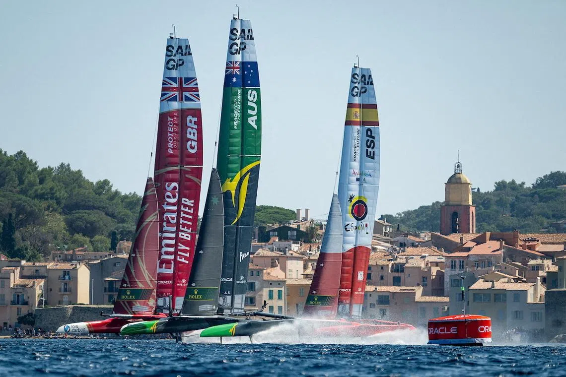 FILE PHOTO: Emirates Great Britain SailGP Team, helmed by Ben Ainslie, Australia SailGP Team, helmed by Tom Slingsby, and Spain SailGP Team, helmed by Diego Botin, sail past a bell tower and the old town of Saint-Tropez on Race Day 2 of the France Sail Grand Prix in Saint-Tropez, France, September 10, 2023. Ian Walton for SailGP/Handout via REUTERS/ File Photo