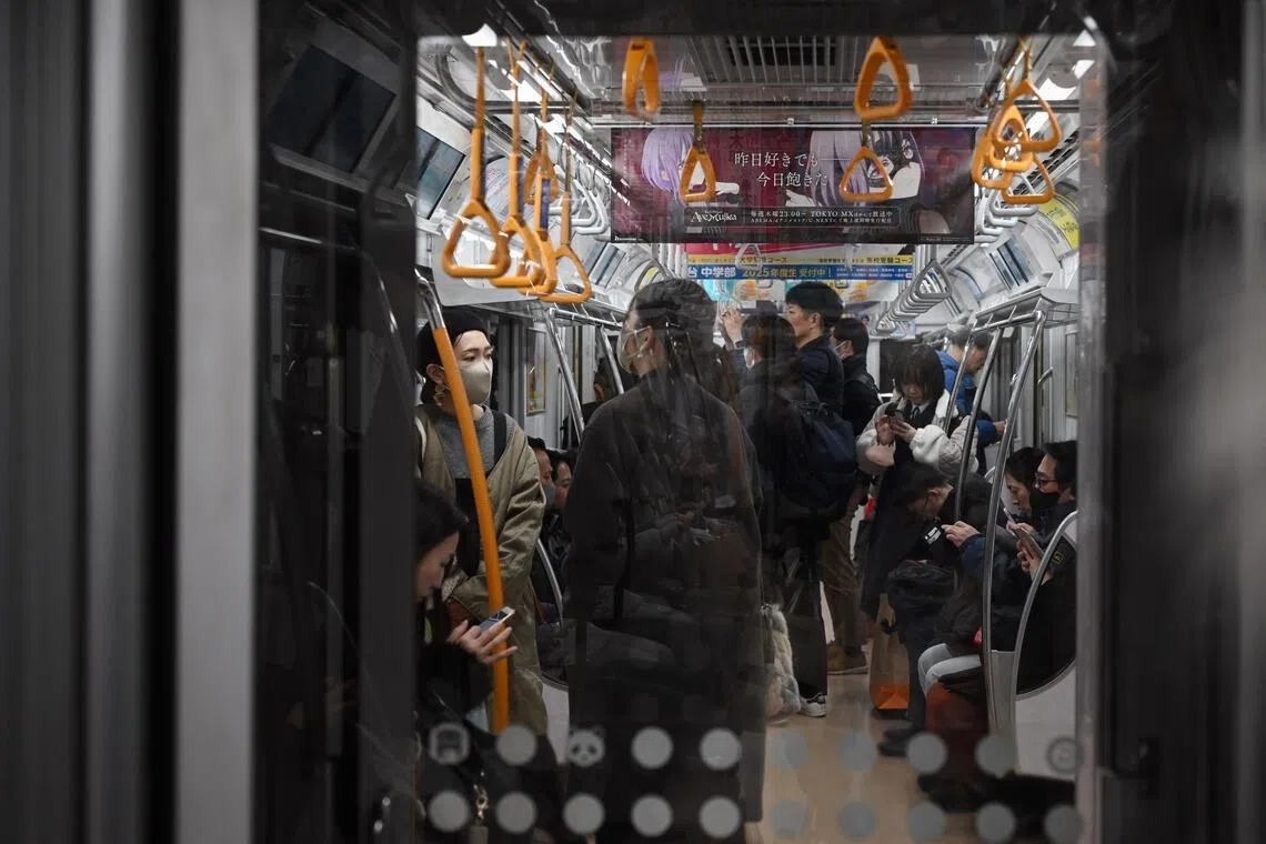 Commuters travel in a train on the JR Yamanote Line, in Tokyo, on Feb 12.