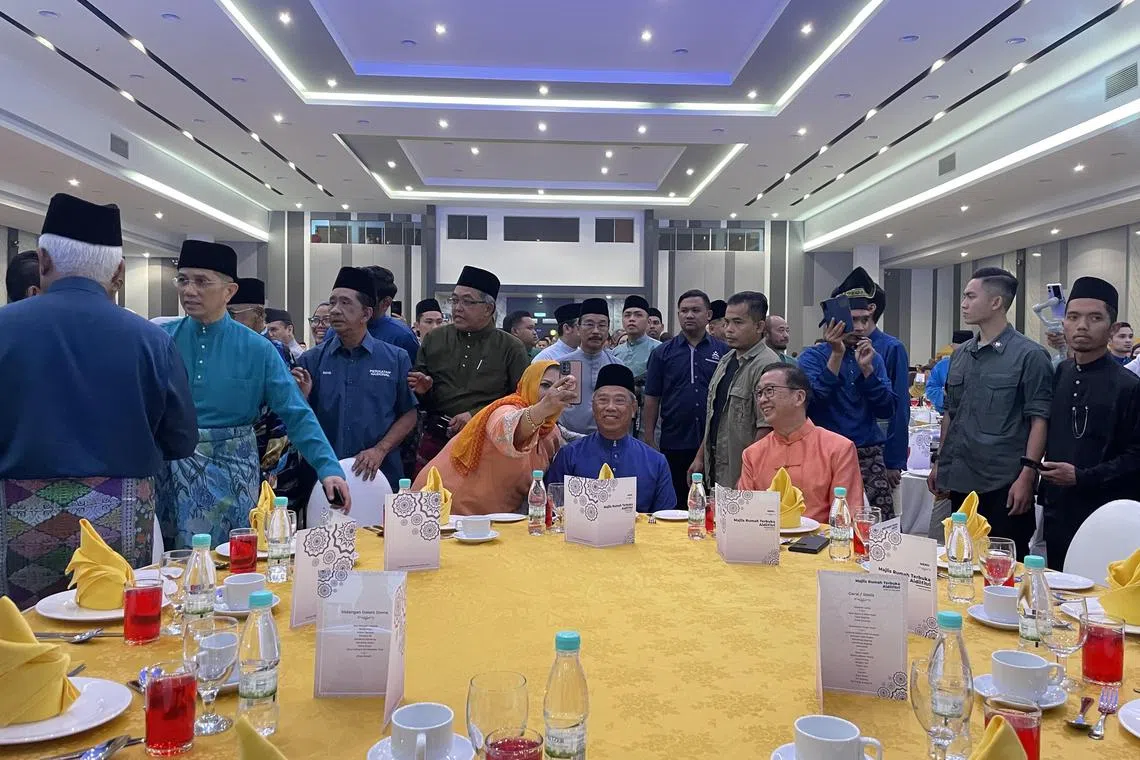 zuraya21
picture caption: A party member posing for a selfie with Perikatan Nasional chairman Muhyiddin Yassin at the Hari Raya Open House in Selangor on Sunday.