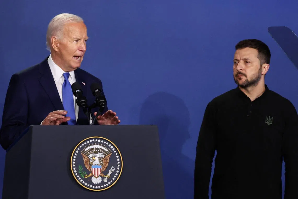 FILE PHOTO: Ukraine's President Volodymyr Zelenskiy listens to U.S. President Joe Biden speak at a Ukraine Compact meeting, on the sidelines of the NATO's 75th anniversary summit in Washington, U.S. July 11, 2024. REUTERS/Yves Herman/File Photo