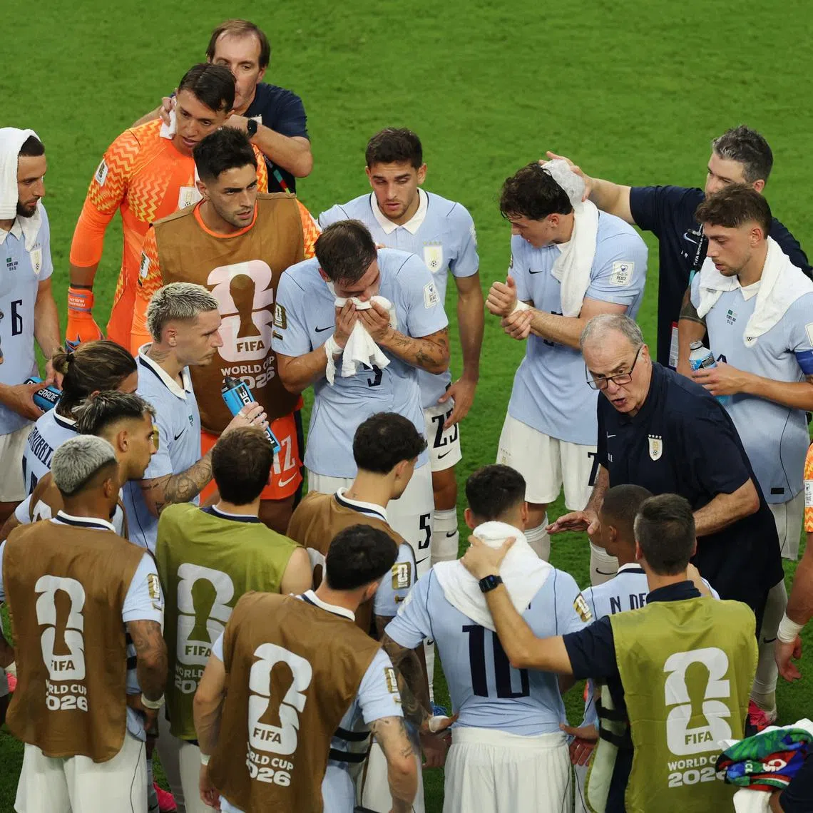 Uruguay coach Marcelo Bielsa speaks to his players during the second half hydration break.