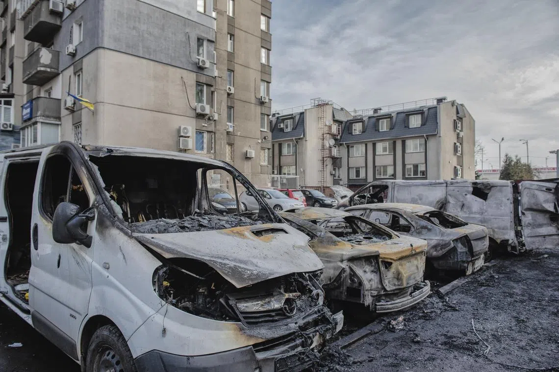 Damaged vehicles are seen near residential buildings in Kyiv, after a Russian missile attack.