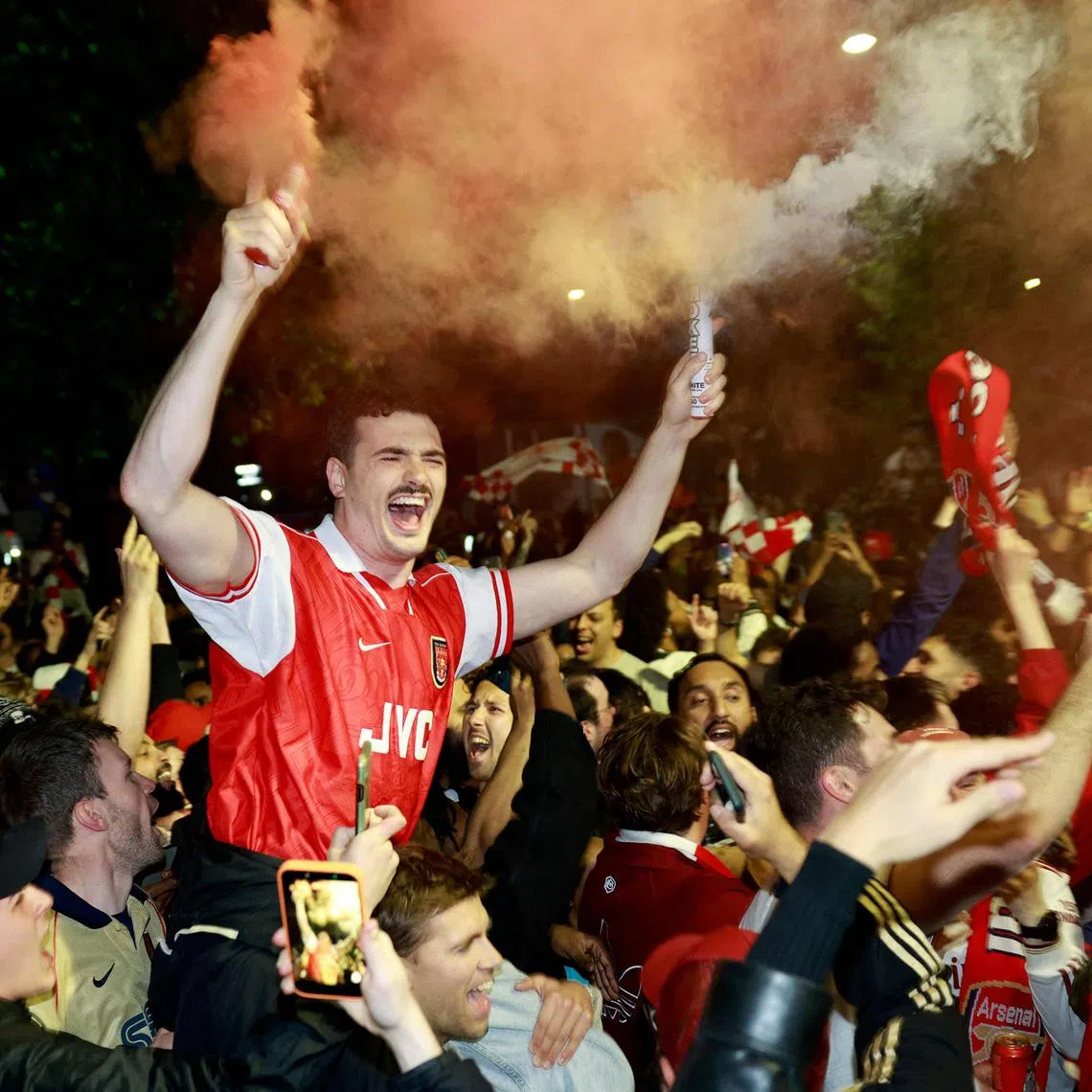 Arsenal fans celebrating their team winning the English Premier League, outside the Emirates Stadium in London on May 19, 2026. Arsenal celebrated their first Premier League title for 22 years late on May 19 after Manchester City were held to a 1-1 draw by Bournemouth, sparking wild scenes of joy around the Emirates Stadium.