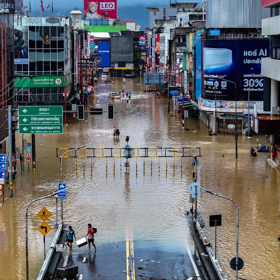 A drone view shows people walking in a flooded area in Hat Yai district on Nov 23.