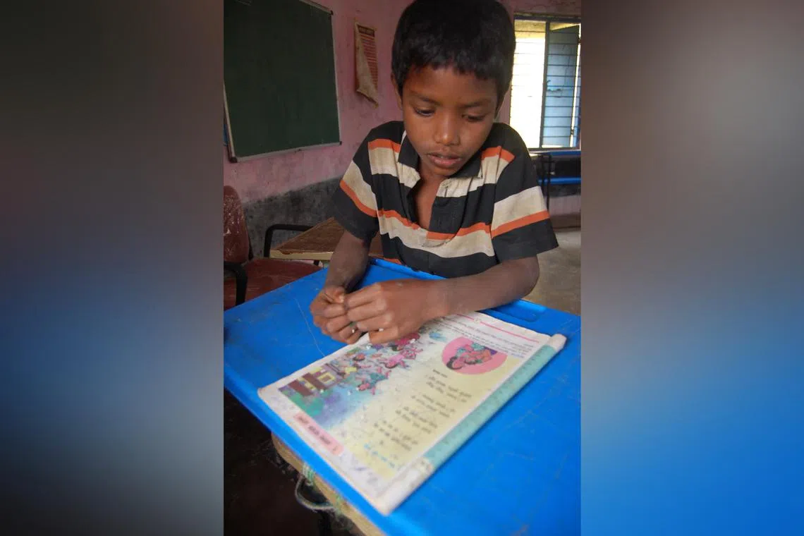 Swapnil Keye Wadde, a Madia Gond child, trying to read from his Marathi textbook at a government primary school in the Indian state of Maharashtra in December 2014.