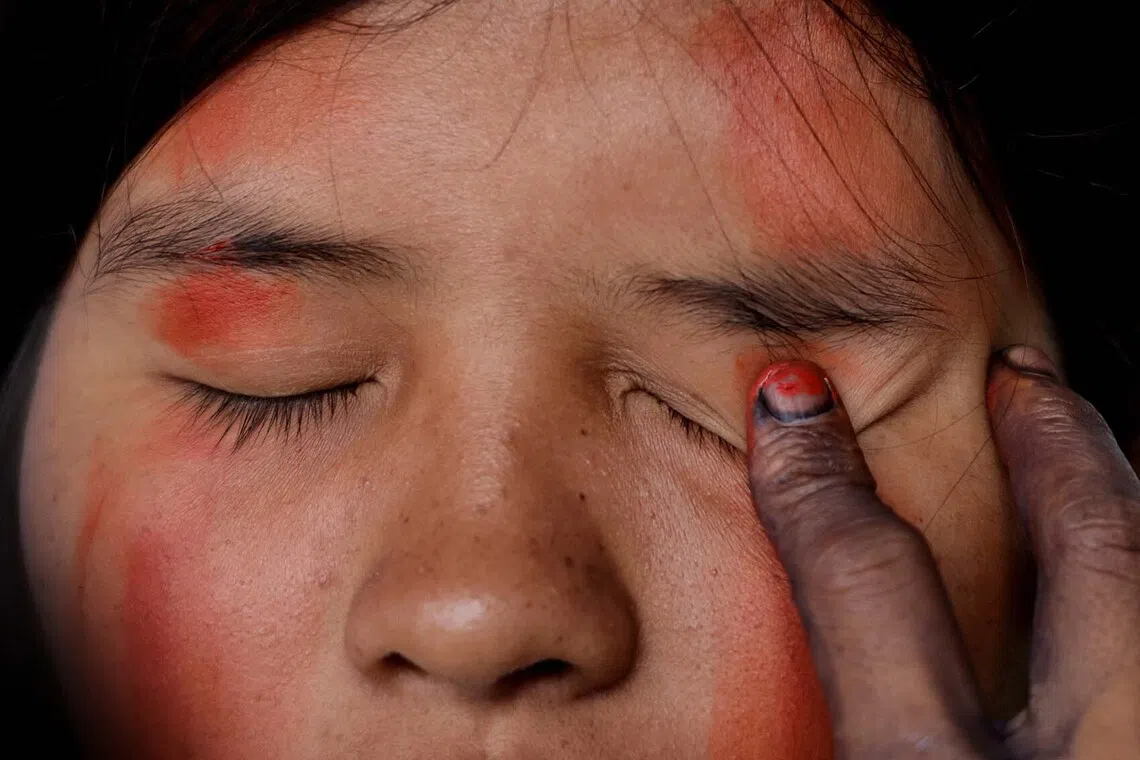 A girl has her face painted during a meeting of indigenous guards from communities across the region, in Sinangoe, Ecuador, who aim to defend the natural resources of the Amazon from exploitation, Dec 2, 2025. 