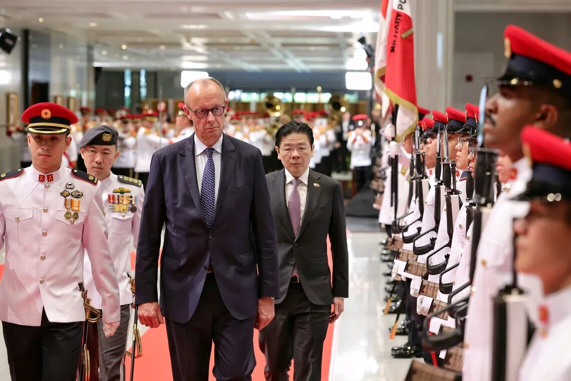 Chancellor of Germany Friedrich Merz (left), accompanied by Prime Minister and Minister for Finance Lawrence Wong, inspecting the guard of honour during a ceremonial welcome at the Parliament House on Oct 27.