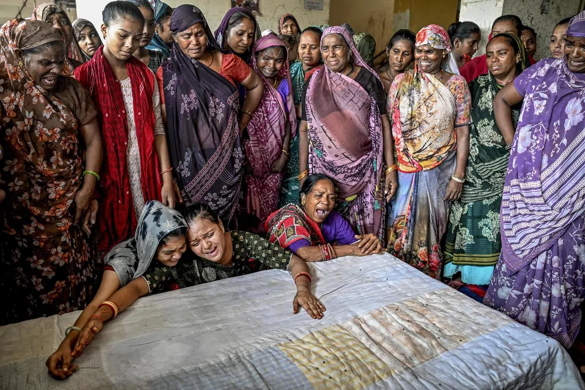 Relatives of one of the victims of the Air India plane crash await the arrival of his body at home in Ahmedabad, India, on June 17, 2025.