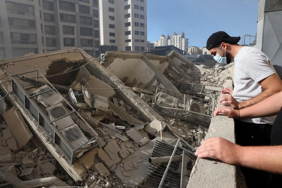 People inspect the damage following Israeli air strikes in Chiyah, Lebanon, on Oct 2.