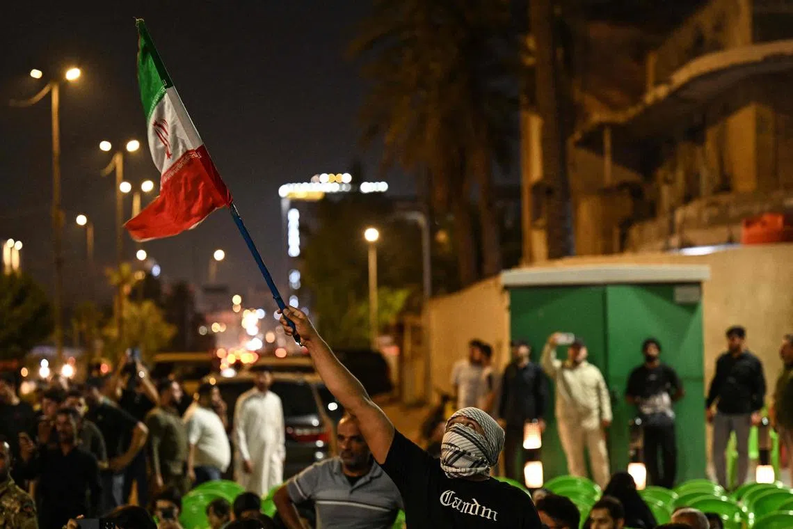 A demonstrator waves an Iranian flag, during a protest against Israel's attack on Iran, in Basra, Iraq on June 13, 2025.  