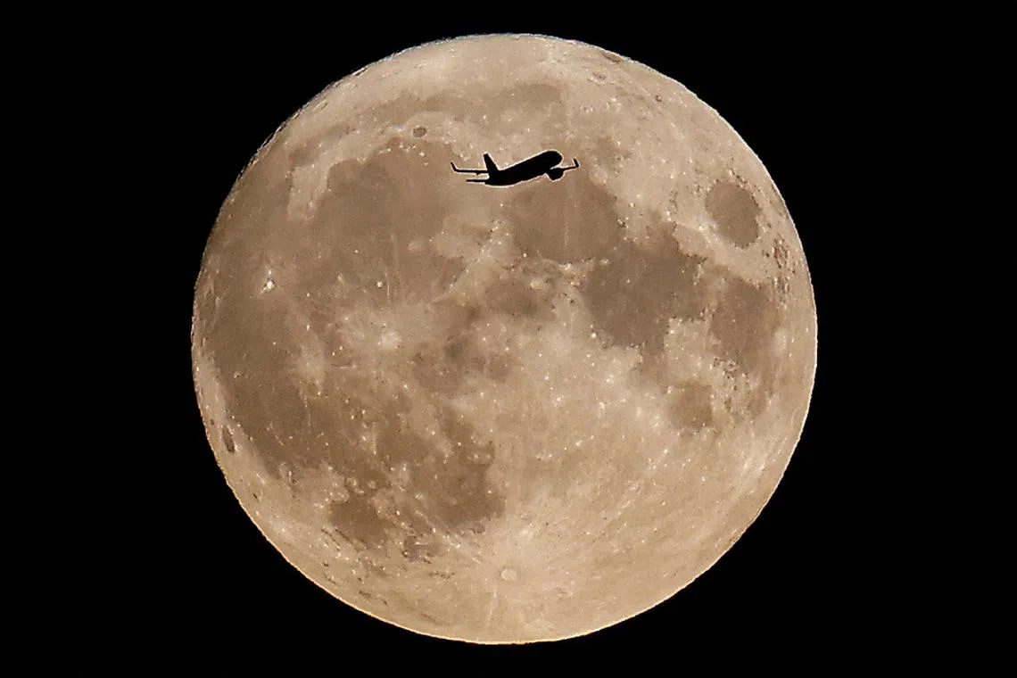 An aircraft flying over London and in front of the the super moon, know as the "Blue Moon", in London, Britain, on August 30, 2023. 