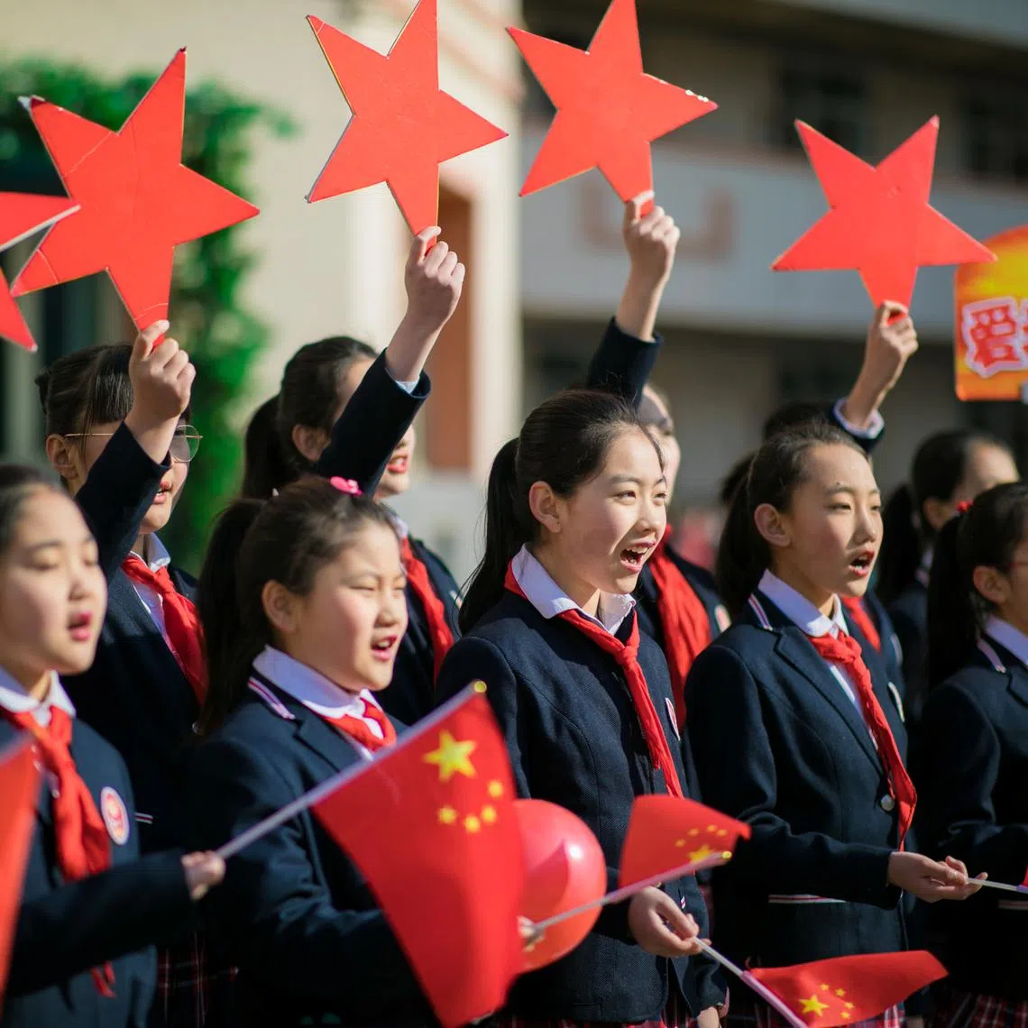 FILE PHOTO: Students hold Chinese flags and cutouts of red stars as they perform a song titled \"Me and my country\", at a ceremony marking the primary school's new semester in Hohhot, Inner Mongolia Autonomous Region, China February 28, 2019.  REUTERS/Stringer/File photo