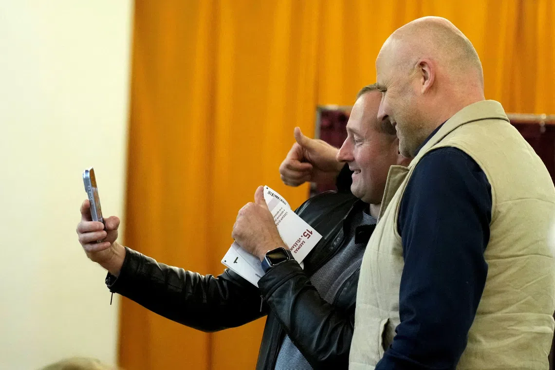 Latvian Prime Minister Andris Kulbergs takes a selfie with a voter during general election in Riga, Latvia, October 3, 2026. REUTERS/Ints Kalnins